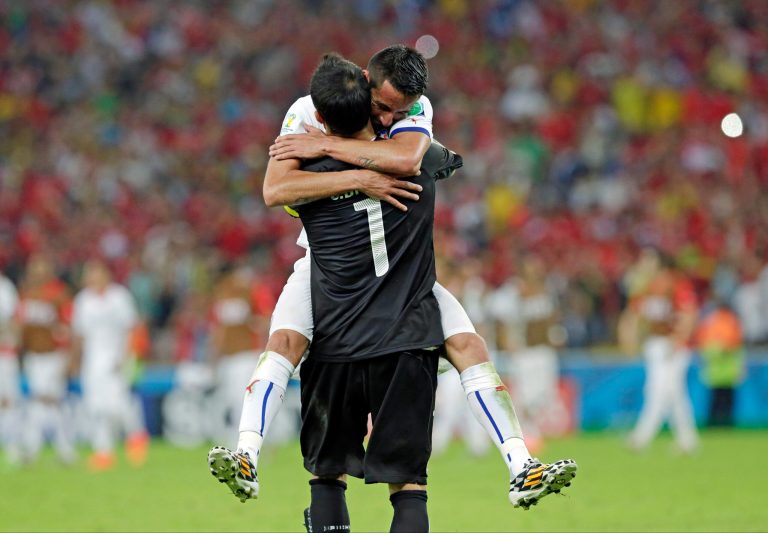 Chile's goalkeeper Claudio Bravo is embraced by Mauricio Isla after the group B World Cup soccer match between Spain and Chile at the Maracana Stadium in Rio de Janeiro, Brazil, Wednesday, June 18, 2014. Defending champion Spain was eliminated from the World Cup after losing to Chile 2-0.  (AP Photo/Bernat Armangue)