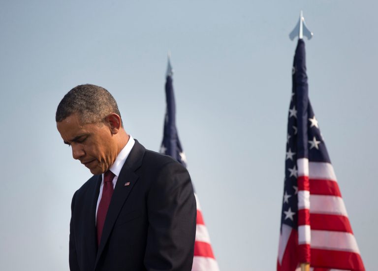   President Barack Obama lowers his head during a moment of silence at the Pentagon, Wednesday, Sept. 11, 2013, during a ceremony to mark the 12th anniversary of the 9/11 attacks. (AP Photo/Pablo Martinez Monsivais)  