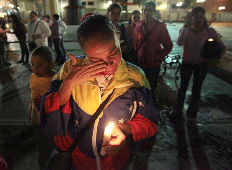   A woman holds a candle as she reacts during a vigil in support of Venezuela's President Hugo Chavez in Caracas, Venezuela, Thursday, Dec. 13, 2012. Chavez is recovering favorably despite suffering complications during cancer surgery in Cuba, his vice president Nicolas Maduro said Thursday amid uncertainty over the Venezuelan leader's health crisis and the country's political future. (AP Photo/Fernando Llano)  