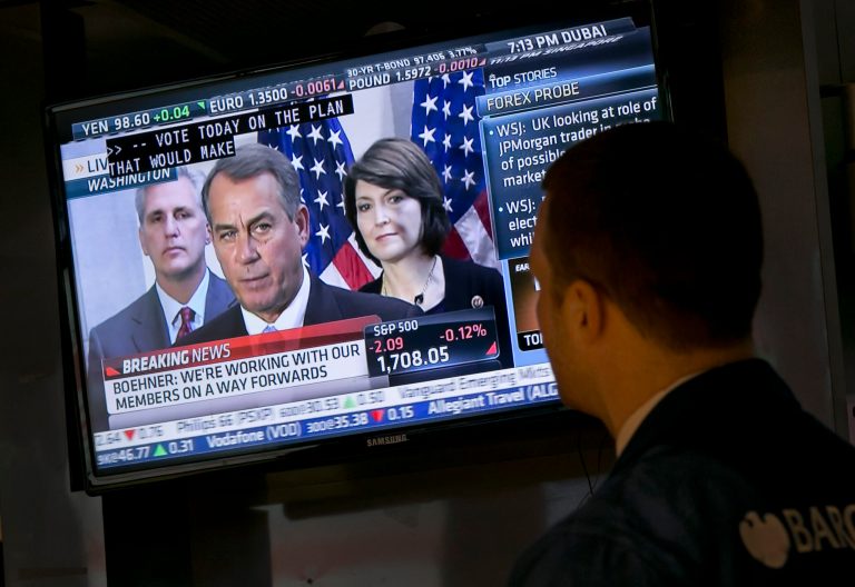A trader watches a television monitor on the floor of the New York Stock Exchange showing a Washington news conference by House Speaker John Boehner on Tuesday. (AP/Richard Drew)