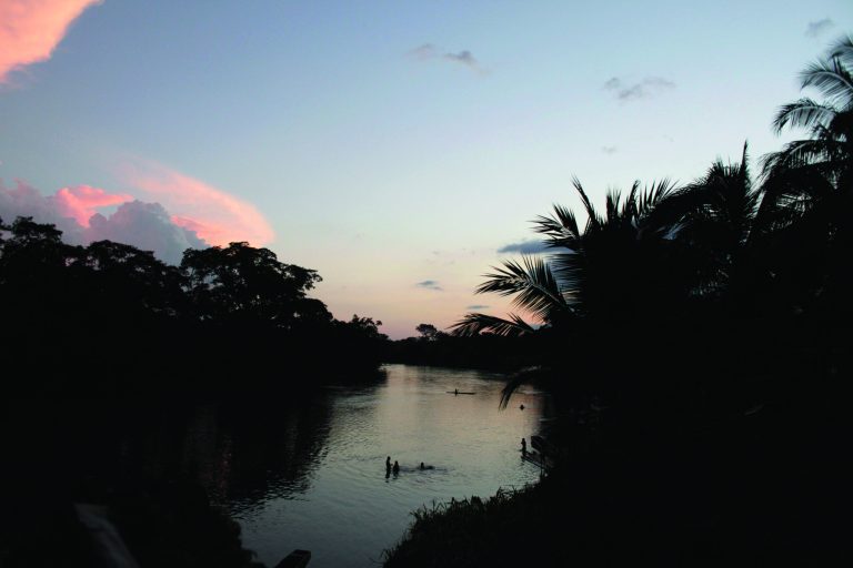 In this June 19, 2012 photo, people bathe in the river as the sun sets in the Darien province on the border with Colombia, in Union Choco, Panama. Panamanian authorities began noticing five years ago that the Darien Gap, the only interruption in the Pan-American Highway, was being used by migrant smugglers, usually to move people from Asia and Africa. Panama's Public Safety Minister Jose Murillo says that the movement of people from Asia and Africa has tapered off but that hundreds of Cubans are now taking the arduous Darien Gap route toward the United States. (AP Photo/Arnulfo Franco)