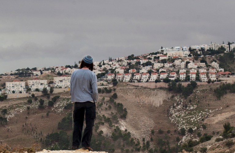   A Jewish settler looks at the West bank settlement of Maaleh Adumim, from the E-1 area on the eastern outskirts of Jerusalem, Wednesday, Dec. 5, 2012. An Israeli-Palestinian showdown over plans for new Jewish settlements around Jerusalem escalated on Wednesday: Israel pushed the most contentious of the projects further along in the planning pipeline, while the Palestinian president said he would seek U.N. Security Council help to block the construction. (AP Photo/Sebastian Scheiner)  