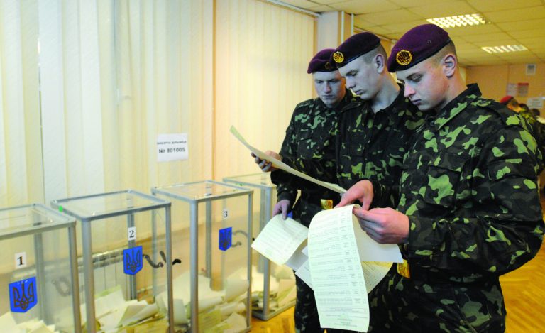 Ukrainian military examine their voting ballots at a polling station in Kiev during parliamentary elections in Ukraine Ukraine, Sunday, Oct. 28, 2012.(AP Photo/Sergei Chuzavkov)