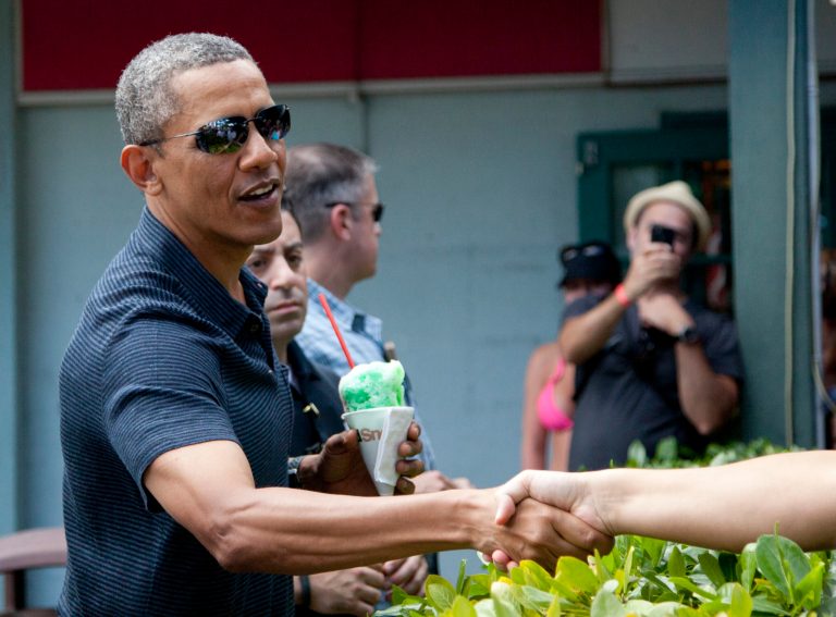 President Barack Obama shakes hands with people waiting to meet him as he holds his shave ice outside Island Snow, Tuesday, Dec. 31, 2014. The first family is in Hawaii for their annual holiday vacation. (AP Photo/Carolyn Kaster)