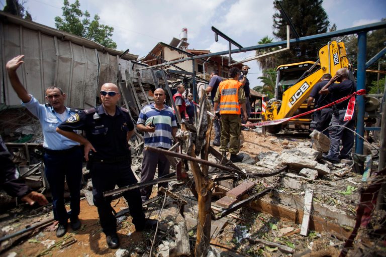FILE - In this Tuesday, July 22, 2014, file photo, Israeli police officers secure a destroyed house that was hit by a rocket fired by Palestinians militants from Gaza, in Yahud, a Tel Aviv suburb near the airport, central Israel. The third Gaza war is playing out very much like the first one some five years ago: We are now at the stage where the harrowing civilian toll in Gaza is at the center of the discourse, eclipsing the rocket attacks by Hamas militants which are the reason for the Israeli assault. In 2009, Hamas was firing relatively small projectiles with minimal range, mostly aimed at border communities surrounding the blockaded Gaza Strip. Now Hamas is firing at Tel Aviv, which is 80 kilometers (50 miles) north of the strip, and even at some cities beyond. (AP Photo/Dan Balilty, File)