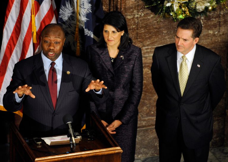   U.S. Rep. Tim Scott, left, speaks during a news conference as South Carolina Gov. Nikki Haley and Sen. Jim DeMint look on at the Statehouse on Monday, Dec. 17, 2012, in Columbia, S.C. Scott was named as DeMint's replacement in the U.S. Senate. (AP Photo/Rainier Ehrhardt)  