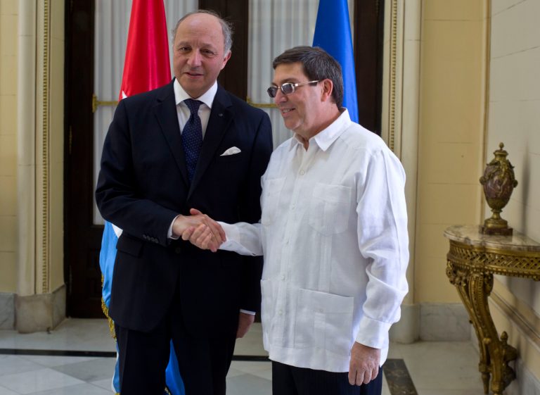 Cuba's Foreign Minister Bruno Rodriguez, right, and France's Foreign Minister Laurent Fabius shake hands toward photographers prior to their meeting at the Foreign Ministry in Havana, Cuba, Saturday, April 12, 2014. France's foreign minister is visiting Cuba for the first time in 30 years at a time when the communist-led Caribbean nation is seeking to draw more foreign investment and improve ties with the European Union. (AP Photo/Ramon Espinosa)