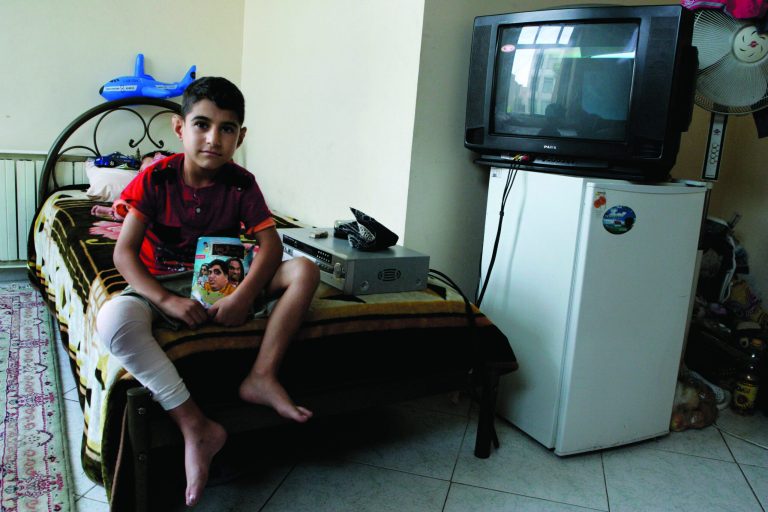 In this Sunday, Aug. 5, 2012 photo, Iranian Milad Rostami, 8, who is suffering from hemophilia, currently recovering from knee surgery, sits on his bed at Iran's Hemophilia Association center, in Tehran, Iran. While medicine and humanitarian supplies are not blocked by the economic embargoes on Iran over its nuclear program, the pressures are clearly evident in nearly every level of Iranian health care. It's a sign of the domino effect of sanctions on everyday life. (AP Photo/Vahid Salemi)