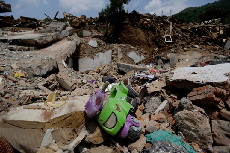 A toy bike lies on the rubble of destroyed houses following a massive earthquake in the town of Longtoushan in Ludian County in southwest China's Yunnan Province Wednesday, Aug. 6, 2014. Some 10,000 troops and hundreds of volunteers have rushed to Ludian to clear roads and dig out possible survivors from the debris, but landslides and bouts of heavy rains have complicated rescue efforts. (AP Photo/Andy Wong)