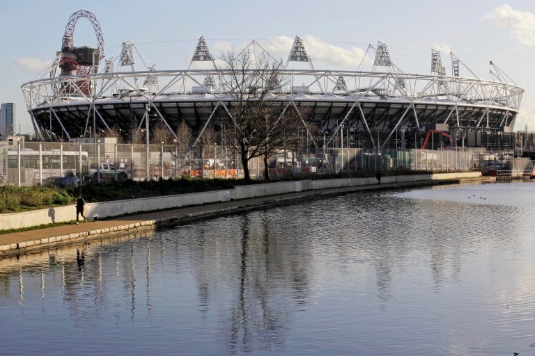   FILE This Friday, Jan. 27, 2012 file photo shows a jogger running on a canal path near the main Olympic Stadium in London. Britain is pouring more money into plans to control the massive crowds expected in London during the Olympics, with the government acknowledging Wednesday June 13, 2012 that it had vastly underestimated the number of people likely to take part in the heady atmosphere of the city. (AP Photo/Sang Tan)  