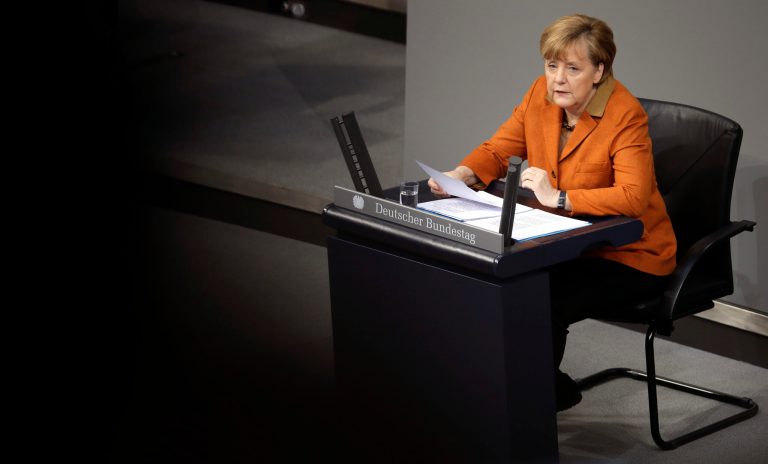 German Chancellor Angela Merkel speaks during a government statement as part of a meeting of the German federal parliament, Bundestag, in Berlin, Germany, Wednesday, Jan. 29, 2014. Due to a hip injury Merkel has to sit during her speech. The reflections are caused by windows at the visitors tribune.  (AP Photo/Michael Sohn)