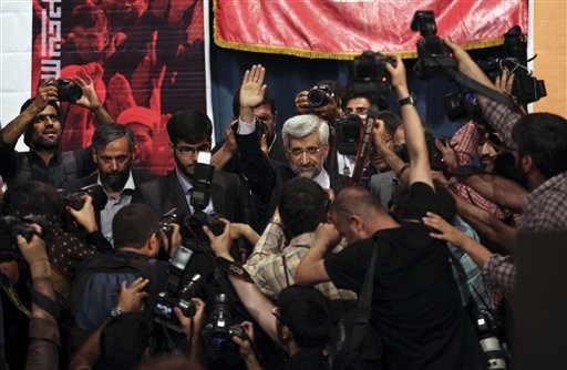 Surrounded by journalists, Iranian presidential candidate Saeed Jalili, center, who is also Iran's top nuclear negotiator, waves at the start of a campaign rally, at Tehran University, in Tehran, Iran, Monday, June 3, 2013. The presidential election will be held on June 14, 2013. (AP Photo/Vahid Salemi)