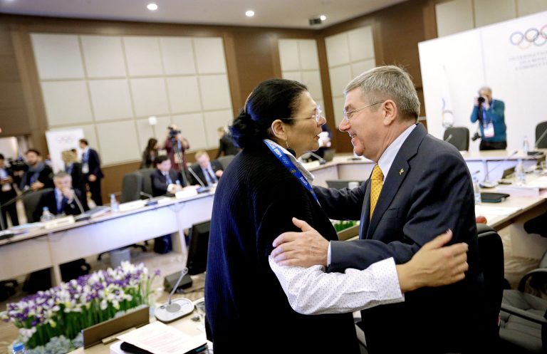 FILE - In this Sunday, Feb. 2, 2014, file photo, International Olympic Committee President Thomas Bach, right, embraces executive board member Anita DeFrantz before the start of an executive board meeting at the 2014 Winter Olympics in Sochi, Russia. DeFrantz won the bronze medal in rowing in the 1976 Olympics, but missed out on the 1980 Moscow Olympics because of the U.S.-led boycott. Now, after all those years, DeFrantz is in Russia for an Olympics. Not as a competitor, but as the highest-ranking American in the international Olympic world. (AP Photo/David Goldman, File)