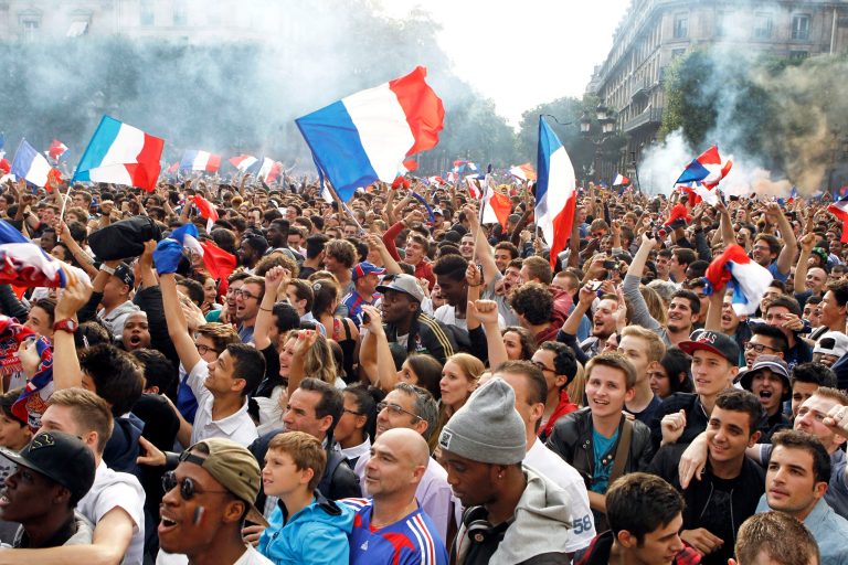 French soccer fans celebrate after France scored the first goal, as they watch the World Cup soccer match between France and Nigeria being shown live on a giant screen, in front of Paris City Hall, Monday June 30, 2014. France won the match 2-0, played at the Estadio Nacional stadium in Brasilia, Brazil.(AP Photo/Remy de la Mauviniere)