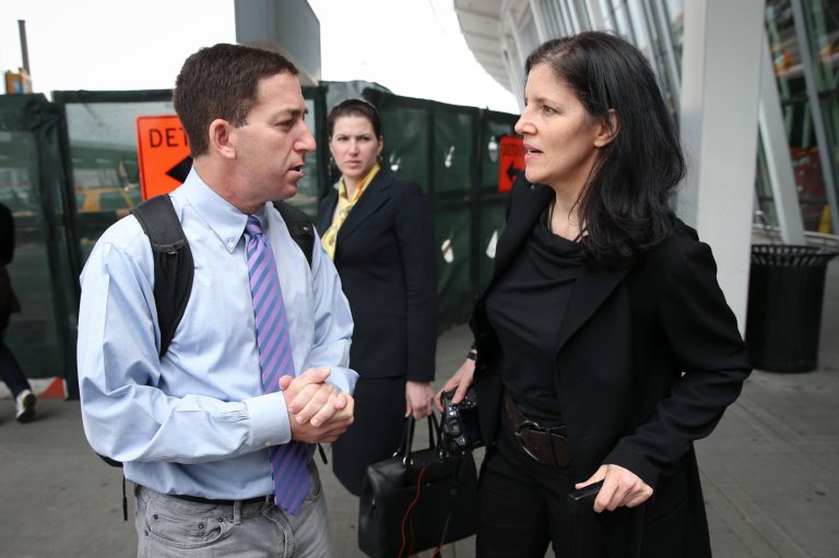 Glenn Greenwald, left, and Laura Poitras arrive at at John F. Kennedy International Airport on Friday in New York. (AP Photo/John Minchillo)