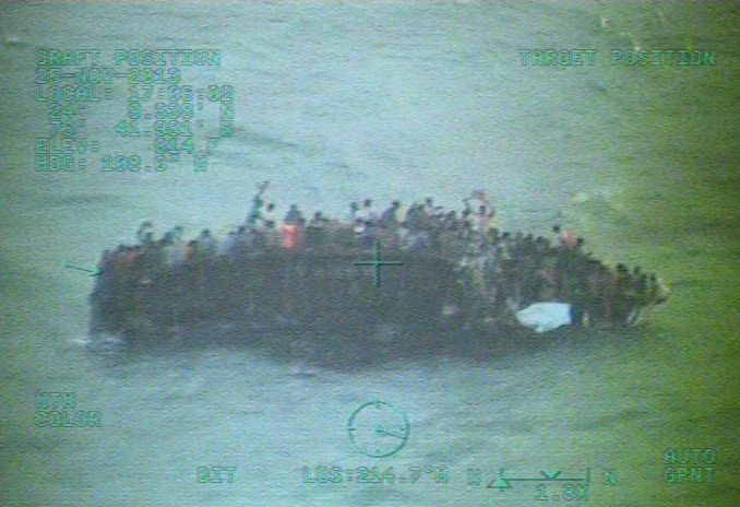 This image taken from video made available by the U.S. Coast Guard shows a group of Haitian migrants sitting on the hull of a capsized sailboat near Staniel Cay, Bahamas on Nov. 26. (AP/U.S. Coast Guard)