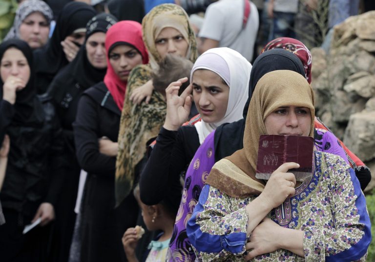 Syrian women wait in line to receive aid from an Islamic relief agency at a refugee camp in the town of Ketermaya, north of the port city of Sidon, Lebanon. The U.S. is considering opening the floodgates to the refugees, according to key senator.Â (AP Photo/Bilal Hussein, file)