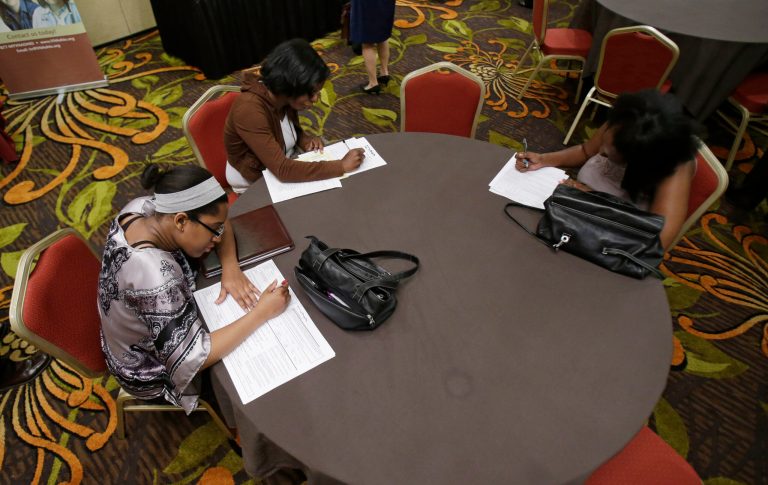 In this Thursday, June 12, 2014 photo, Desirae Gooch, left, fills out an application for a nurse's assistant job, alongside other job seekers filling out applications at the Cleveland Career Fair in Independence, Ohio. The Labor Department issues its May report on job openings and labor turnover on Tuesday, July 8, 2014. (AP Photo/Tony Dejak)