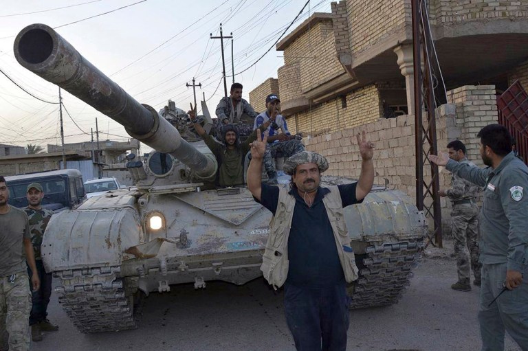 Iraqi security forces celebrate in central Fallujah, Iraq, after fighting against the Islamic State militants Friday, June 17, 2016. (AP Photo)