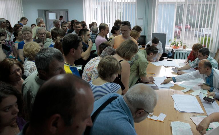Ukrainians stand in line to receive their ballot papers at a polling station during presidential and mayoral elections in Kiev, Ukraine, Sunday, May 25, 2014. Ukraine's critical presidential election got underway Sunday under the wary scrutiny of a world eager for stability in a country rocked by a deadly uprising in the east. (AP Photo/Sergei Chuzavkov)