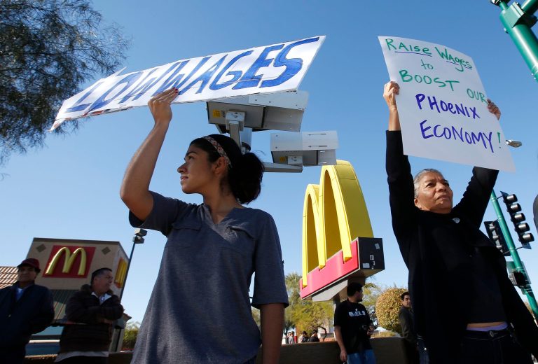 People hold signs as they protest.
