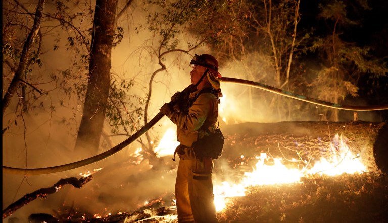 Firefighters continue to battle 13 wildfires that have destroyed more than 210,000 acres and 5,700 structures, and have killed 42 people. (AP Photo/Marcio Jose Sanchez)