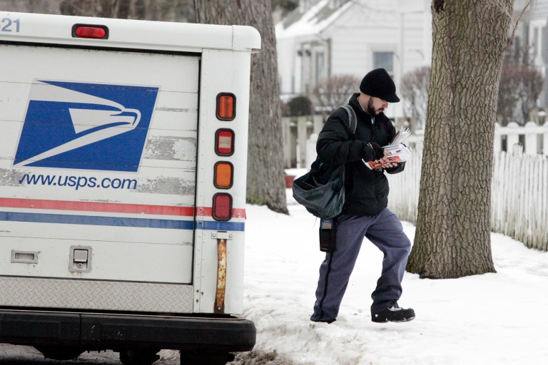 United States Postal Service carrier Brandon Liverman delivers mail Thursday February 7, 2013 in LaPorte, Ind. The United States Post Service announced it will end Saturday mail delivery. (AP Photo/The LaPorte Herald-Argus, Bob Wellinski)