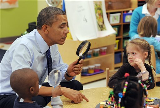 President Barack Obama looks through a spy glass as a little girl stares at him during a visit to College Heights Early Childhood Learning Center in Decatur, Ga. on Thursday, Feb. 14, 2013. The president visited the school to highlight their pre-kindergarten program. He is proposing a nationwide initiative for children in pre-kindergarten.  (AP Photo/Atlanta Journal-Constitution, Johnny Crawford, Pool)