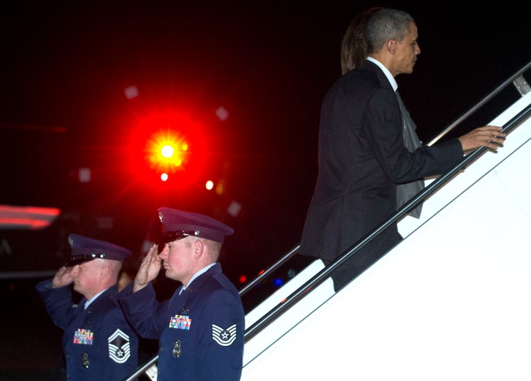 President Barack Obama and first lady Michelle Obama board Air Force One, Friday, Dec. 20, 2013, in Andrews Air Force Base, Md., en route to Hawaii for their annual family vacation. (AP Photo/Carolyn Kaster)