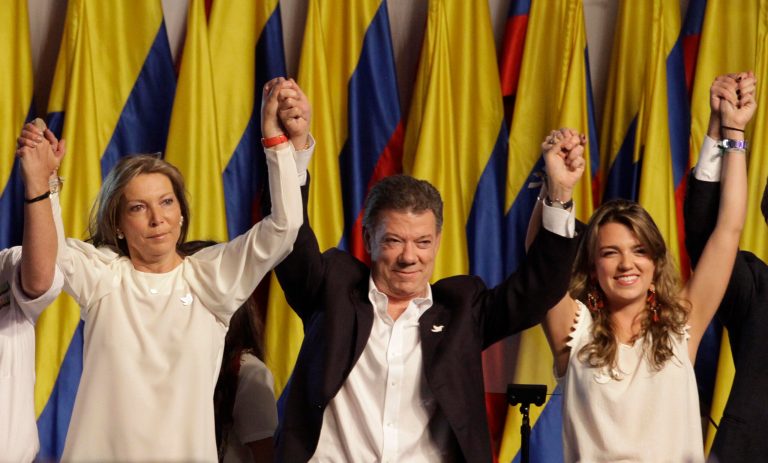 President Juan Manuel Santos, center, celebrates his victory in the presidential runoff, with first lady Maria Clemencia Rogriguez, left, and his daughter Maria Antonia Santos at his campaign headquarters in Bogota, Colombia, Sunday, June 15, 2014. (AP Photo/Javier Galeano)