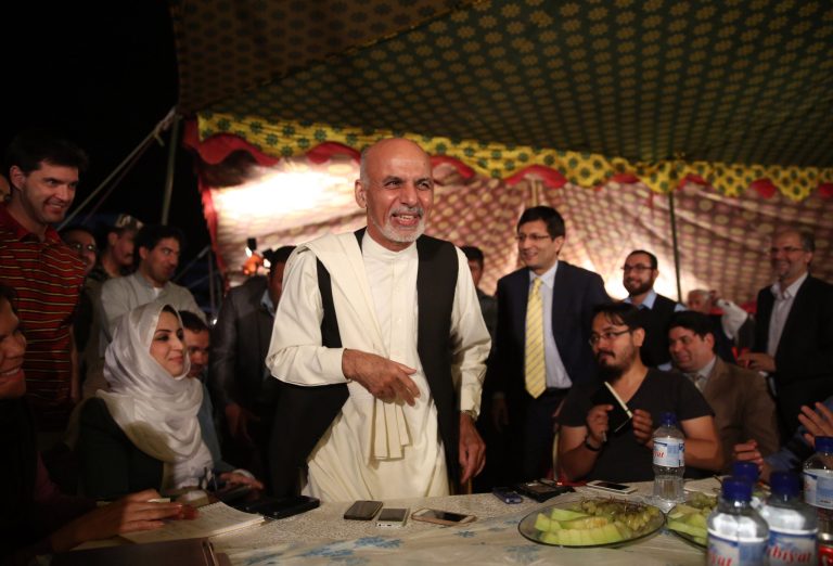 Afghan presidential candidate Ashraf Ghani Ahmadzai, center, greets local and international journalists behind a dinner table after a news conference at his resident in Kabul, Afghanistan, Wednesday, Sept. 10, 2014. Ghani Ahmadzai, one of two presidential candidates in Afghanistan, said that talks on a national unity government will continue but that it cannot accommodate two leaders. (AP Photo/Massoud Hossaini)