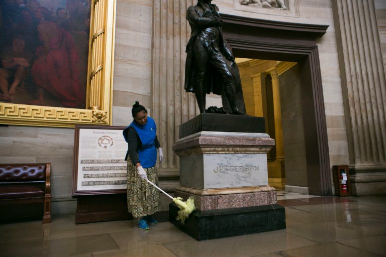 A custodial worker dusts a statue of Thomas Jefferson inside the Capitol Rotunda on Tuesday. (Graeme Jennings/Examiner)