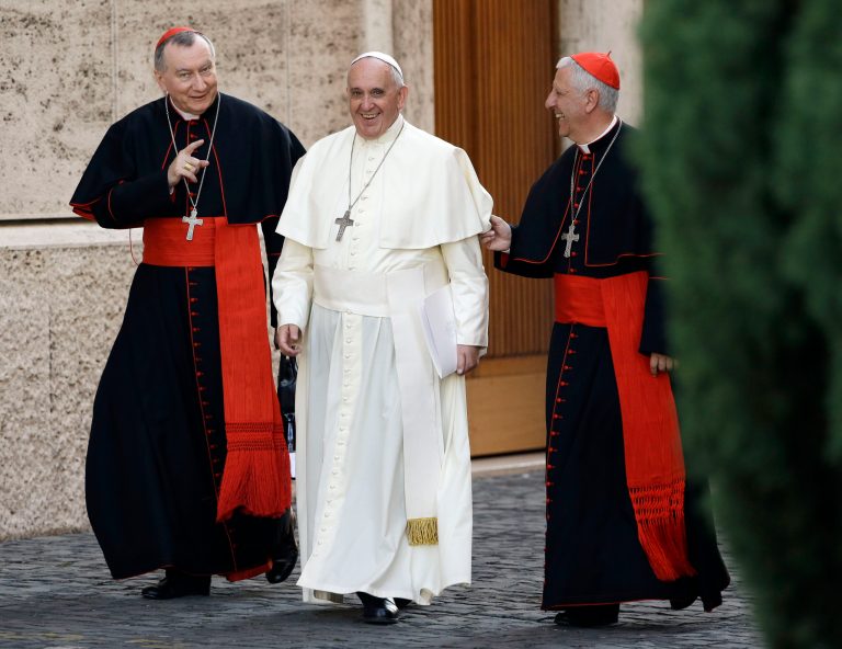 Pope Francis smiles as he walks alongside Vatican Secretary of State Pietro Parolin, left, and Cardinal Giuseppe Versaldi, prior to start an afternoon session of a two-week synod on family issues at the Vatican, Wednesday, Oct. 8, 2014. (AP Photo/Gregorio Borgia)