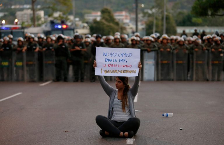 A demonstrator holds up a sign that reads in Spanish 