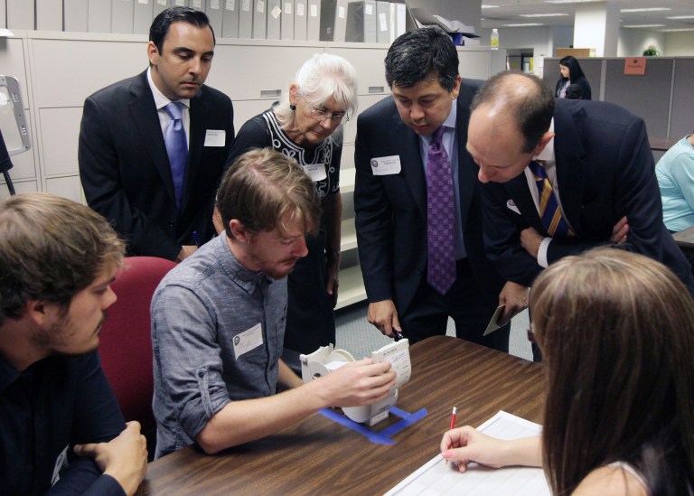 Observers watch election worker Micah Kagler as he checks the vote on the receipt of a touch screen ballot in the California controller race at the Kern County Elections Division in Bakersfield, Calif. on Friday, July 11, 2014. It is the first recount in a statewide candidate election in modern California history. (AP Photo/The Bakersfield Californian, Felix Adamo)