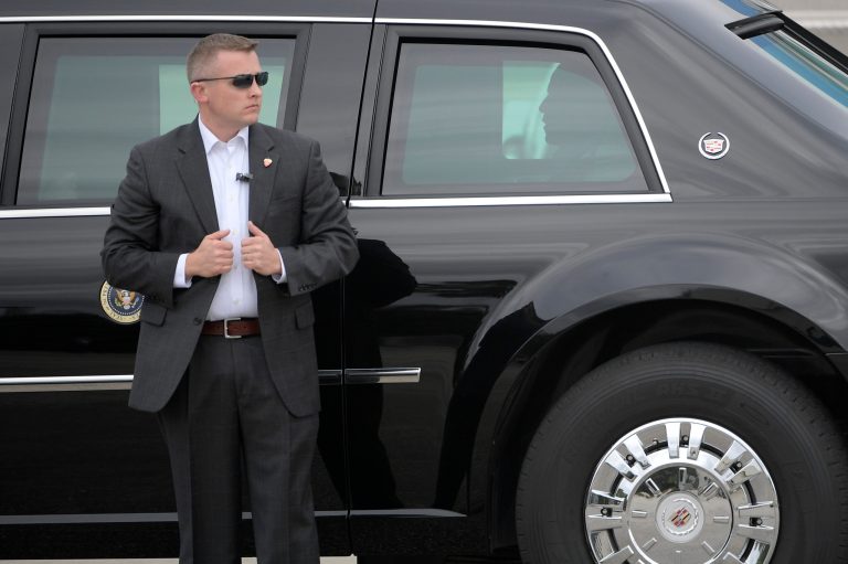 A Secret Service agent stands watch as President Barack Obama sits in the back of his limousine after arriving aboard Air Force One at Orlando International Airport in Orlando, Fla., Sunday, Nov. 6, 2016, for a campaign event for Democratic presidential candidate Hillary Clinton at Osceola County Stadium. (AP Photo/Phelan M. Ebenhack)