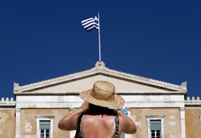   A tourist takes photos of the Parliament in Syntagma square in central Athens, Thursday, June 14, 2012. Greece faces crucial national elections on Sunday, that could ultimately determine whether the debt-saddled, recession bound country remains in the eurozone. (AP Photo/Petros Karadjias)  