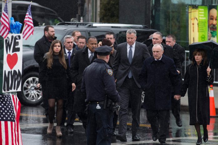 From right, Rikki Klieman, wife of New York Police Commissioner Bill Bratton, Bill Bratton, and New York City Mayor Bill de Blasio, arrive at the wake of New York Police Department officer Wenjian Liu at the Aievoli Funeral Home, Saturday, Jan. 3, 2015, in the Brooklyn borough of New York. Liu and his partner, officer Rafael Ramos, were killed Dec. 20 as they sat in their patrol car on a Brooklyn street. The shooter, Ismaaiyl Brinsley, later killed himself. (AP Photo/John Minchillo)