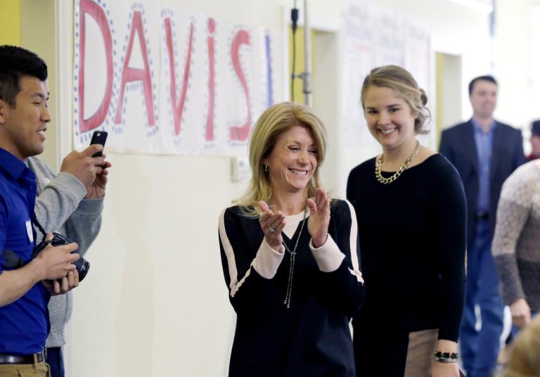 FILE - In this March 4, 2014 file photo, Texas State Sen. Wendy Davis applauds her volunteers at her campaign headquarters in Fort Worth, Texas. As the tea party swaggers into the Texas GOP Convention this week dominant as ever and empowered to toughen the Republican platform on immigration and spending, Democrats are welcoming the new wave of insurgency, claiming the rightward pull has finally gone too far for voters to stomach.  (AP Photo/LM Otero, File)