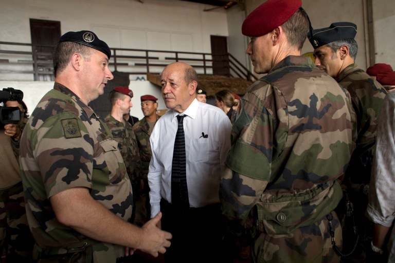 FILE - This Thursday, Jan. 2, 2014, file photo shows French Defense Minister Jean-Yves Le Drian talking with French soldiers from Operation Sangaris, at Mpoko Camp in Bangui, Central African Republic. France will broaden its military presence in Africa's turbulent Sahel region with specialized new outposts to better fight the terror threat from extremist groups such as al-Qaida, the defense minister said Tuesday. In an exclusive interview with The Associated Press, Jean-Yves Le Drian said France is moving toward a regional counterterrorism approach in former French colonies such as Chad, Ivory Coast, Burkina Faso, Niger and Mali. (AP Photo/Rebecca Blackwell, File)