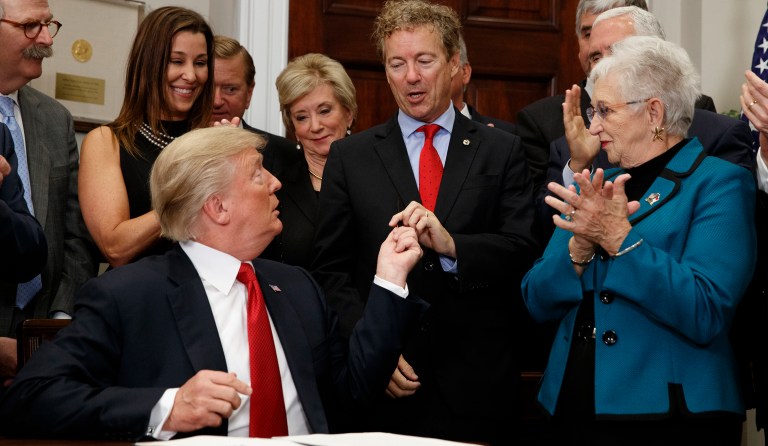 President Donald Trump hands a pen that he used to sign an executive order on healthcare to Sen. Rand Paul, R-Ky., in the Roosevelt Room of the White House, Thursday, Oct. 12, 2017, in Washington. (AP Photo/Evan Vucci)