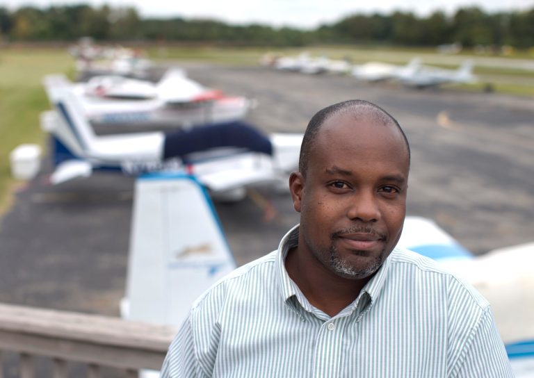 College Park Airport senior operations specialist Langston Majette is photographed overlooking planes and a runway at the College Park Airport in College Park , Md., Wednesday, Sept. 24, 2014. Long the bane of gardeners and unwary motorists, soaring deer populations are also nuisances for airports and threats to pilots, especially at this time of year, according to aviation and wildlife experts. College Park Airport is a smaller airport struggling to keep deer out. (AP Photo/Carolyn Kaster)