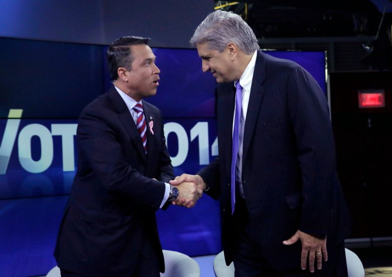 Incumbent Republican Rep. Michael Grimm, left, and Democratic challenger Domenic Recchia shake hands before a recorded, televised debate for the 11th Congressional District race Friday, Oct. 17, 2014, at WABC-TV in New York. (AP Photo/Richard Drew, Pool)