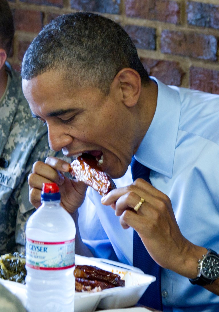   President Barack Obama take a bite of a rib as he visits a Kenny's BBQ restaurant in Washington, Wednesday, June 13, 2012. (AP Photo/Carolyn Kaster)  