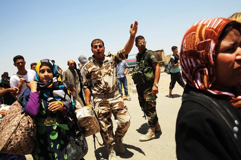 Kurdish soldiers block Iraqis who have fled recent fighting in the cities of Mosul and Tal Afar as they try to enter a temporary displacement camp on July 2 in Khazair, Iraq. (Photo by Spencer Platt/Getty Images)