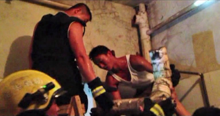 In this still image taken from video from Saturday May 25, 2013, a firefighter removes a section of a sewage pipe where a newborn baby appears trapped, in Pujiang in east China's Zhejiang province. Chinese firefighters have rescued a newborn boy from a sewer pipe below a squat toilet, sawing out an L-shaped section and then delicately dismantling it to free the trapped baby, who greeted the rescuers with cries. A tenant heard the baby's sounds in the public restroom of a residential building in Zhejiang province in eastern China on Saturday and notified authorities, according to the state-run news site Zhejiang News. A video of the two-hour rescue that followed was broadcast widely on Chinese news programs and websites late Monday and Tuesday. (AP Photo) CHINA OUT
