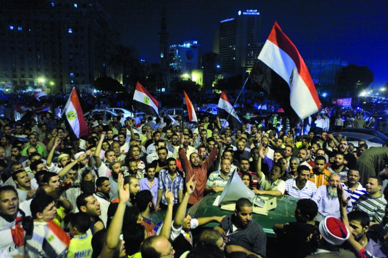 Thousands of supporters of Egypt's Islamist President Mohammed Morsi celebrate as they listen to his speech on a microphone over a car in Tahrir Square, birthplace of the uprising that ousted Hosni Mubarak 18 months ago, in Cairo late Sunday, Aug. 12, 2012. Morsi ordered the retirement of the defense minister and chief of staff on Sunday and made the boldest move so far to seize back powers that the military stripped from his office right before he took over. (AP Photo/Amr Nabil)