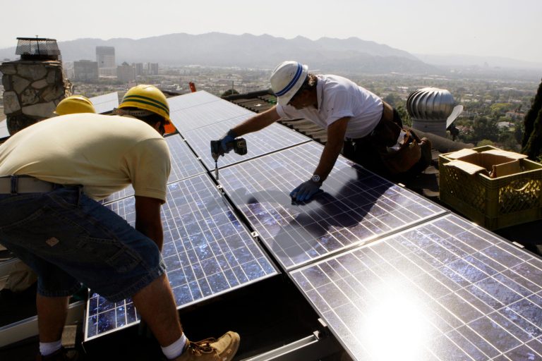 California Green Design workers install solar electrical panels on the roof of a home in Glendale, Calif. The Obama administration announced a plan on July 19 to help middle-class and low-income communities put solar panels on their roofs. (AP Photo)