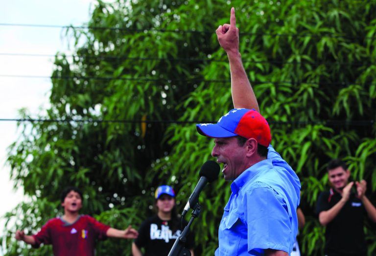 Opposition presidential candidate Henrique Capriles speaks to supporters at a campaign rally in Puerto Cabello, Venezuela, Wednesday, Sept. 12, 2012. Violence broke out before the opposition campaign event got started, between supporters of Capriles and supporters President Hugo Chavez. Tensions have sporadically erupted into violent clashes and scuffles between supporters of the two candidates ahead of the Oct. 7 presidential vote. (AP Photo/Ariana Cubillos)