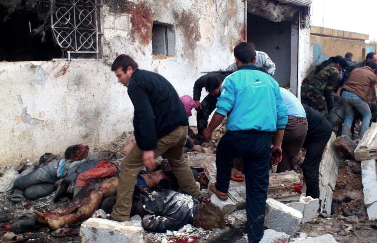   EDS NOTE: GRAPHIC CONTENT - This image taken from the Edlib News Network, ENN, which has been authenticated based on its contents and other AP reporting, shows Syrians removing the bodies of those killed after a government airstrike hit the Hama Suburb of Halfaya, Syria, Sunday, Dec. 23, 2012. A government airstrike on a rebel-held town in central Syria killed tens of people on Sunday, activists said, while the international envoy charged with negotiating an end to the countryâs civil war was in Damascus to meet with top officials. (AP Photo/Edlib News Network ENN)  